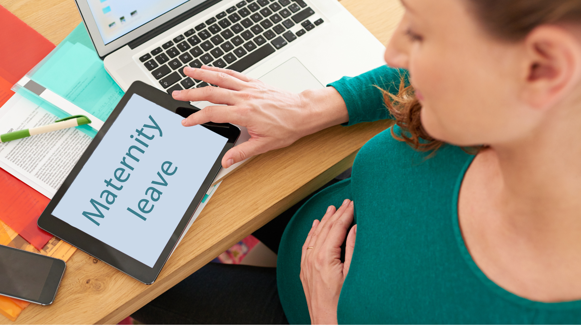 Embarazada con un ipad donde se lee maternity leave